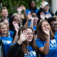 A group of Thompson Scholars waving.